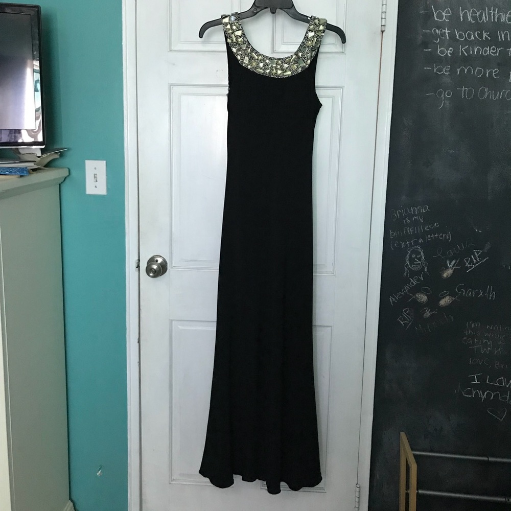 Floor length open back black gown.